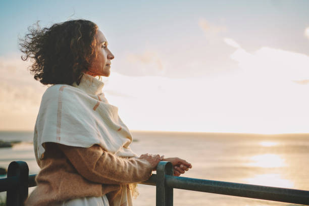 Mulher de 50+ sorrindo e olhando para o horizonte, representando a ideia de reaprender a sonhar depois dos 50.